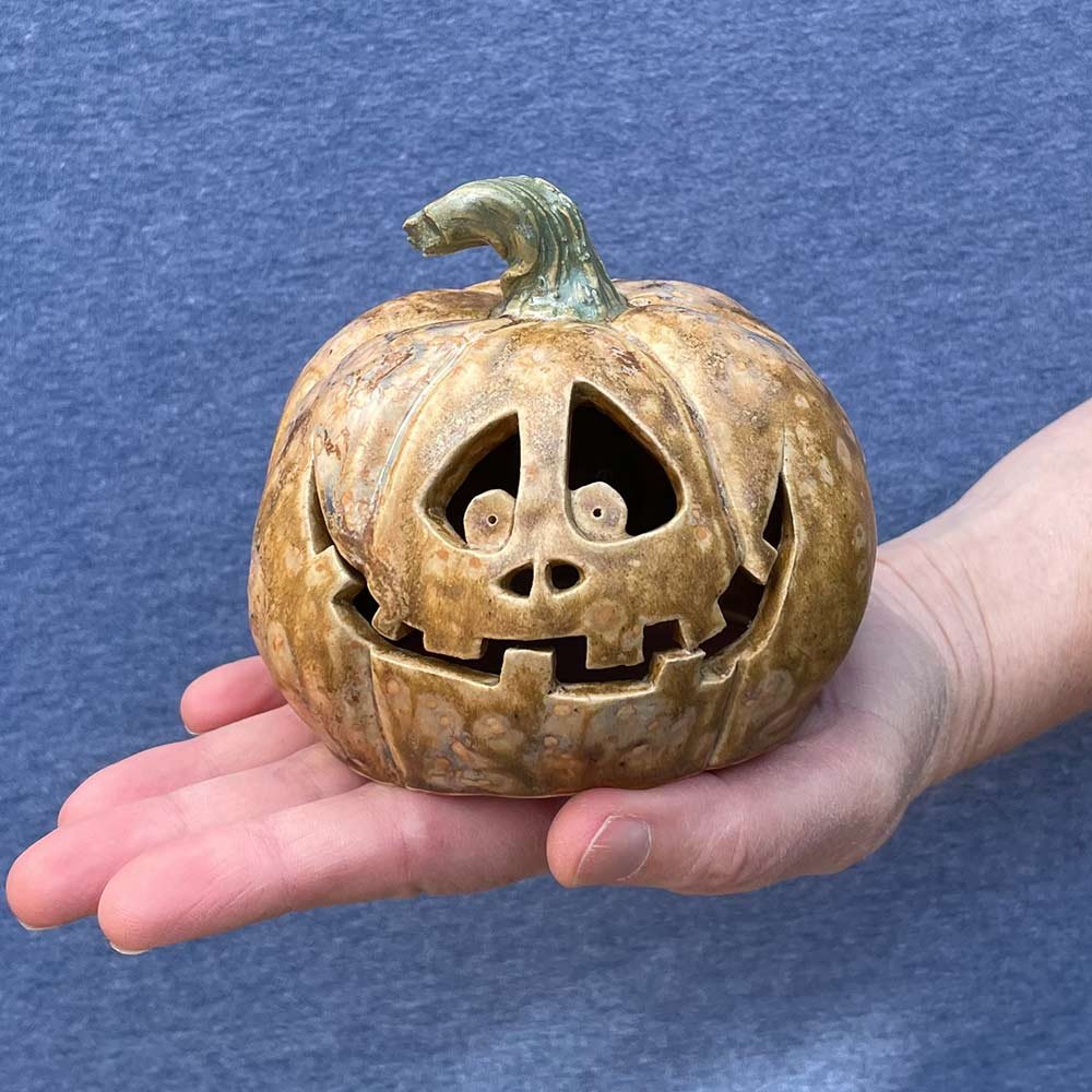 Carved ceramic pumpkin in white by Lucy Ormsby Pottery - in the hand