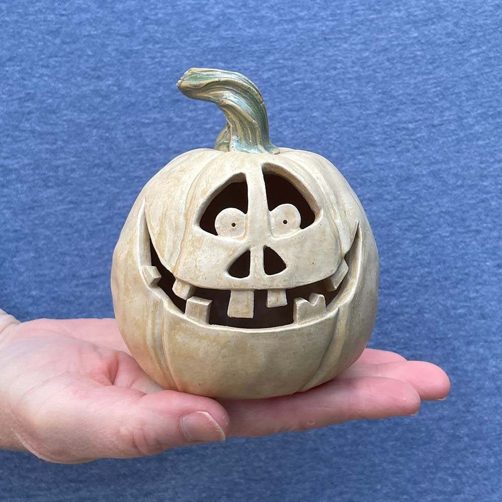 Carved ceramic pumpkin by Lucy Ormsby pottery in hand for scale