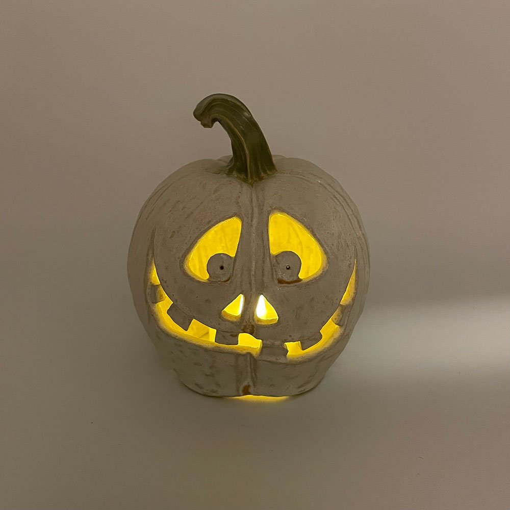 Carved ceramic pumpkin in white by Lucy Ormsby Pottery - lit up