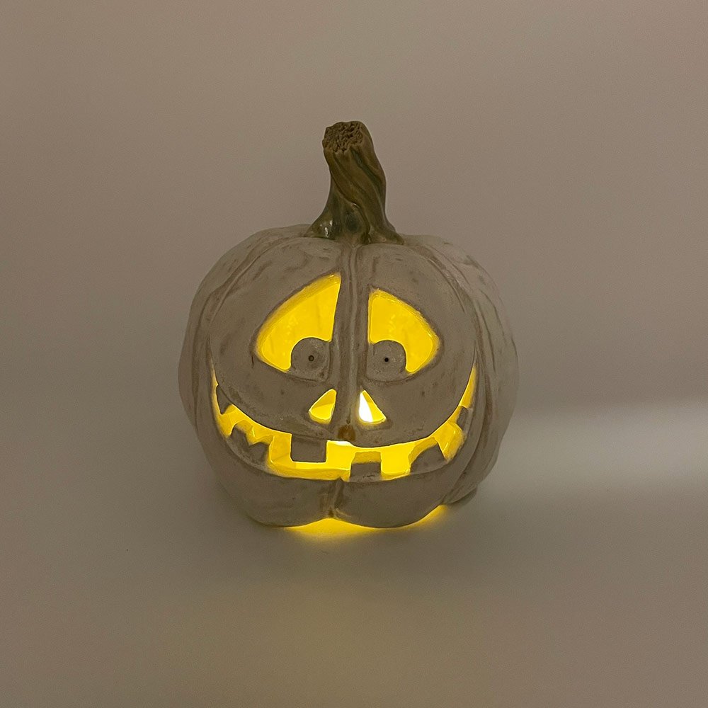 Carved ceramic pumpkin in white by Lucy Ormsby Pottery - lit up